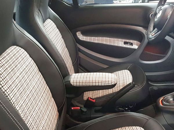 parte anteriore di interno auto personalizzata con inserti dei sedili e dei pannelli porta in tessuto a quadretti bianchi e neri