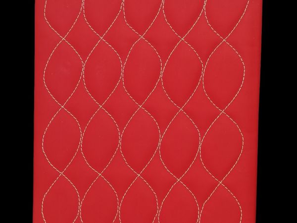 pannello campione rosso con cuciture bianche che riproducono un disegno ondulato