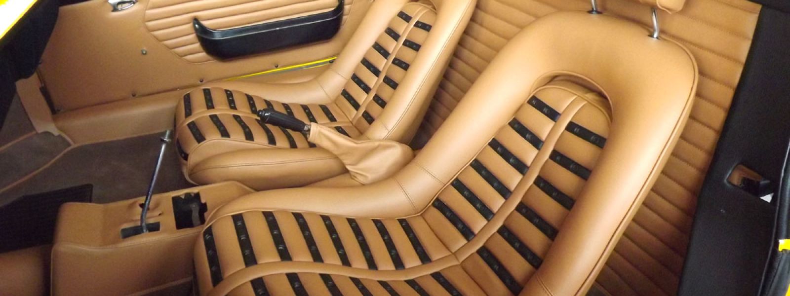 sedili anteriori di auto d'epoca in pelle a righe beige e nera