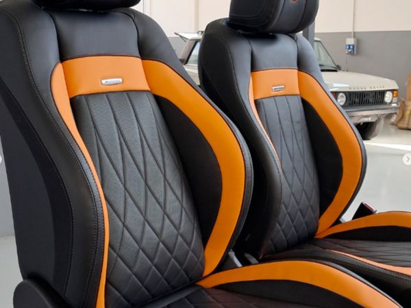 sedili auto neri con lavorazione a rombi nello schienale e bordo arancione